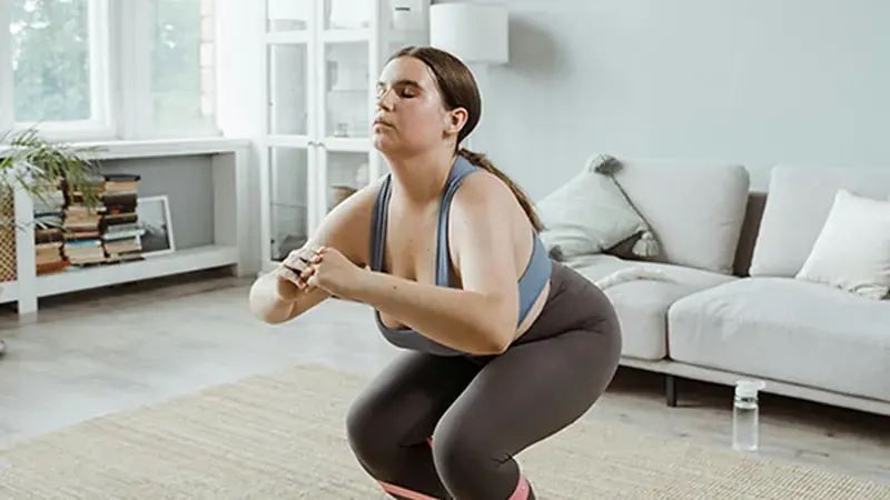 Woman exercising at home as part of a weight loss treatment plan